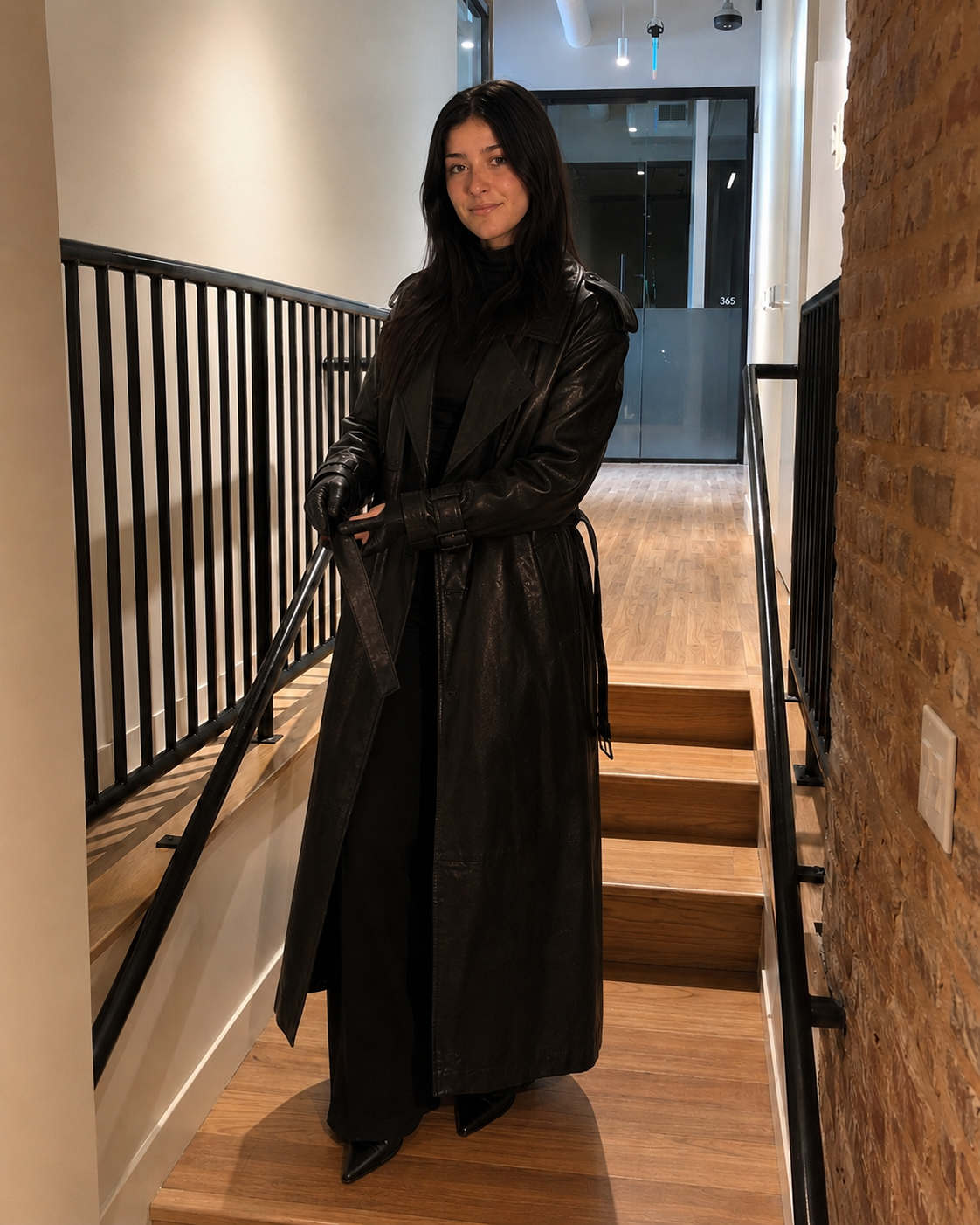 Woman in a black leather coat making a gesture in a hallway